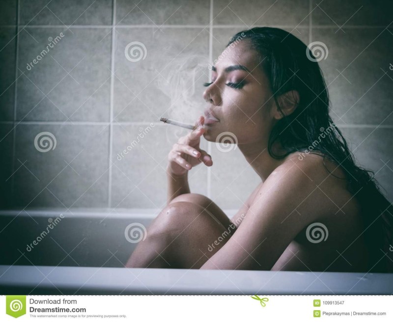 Женщина курит в ванной